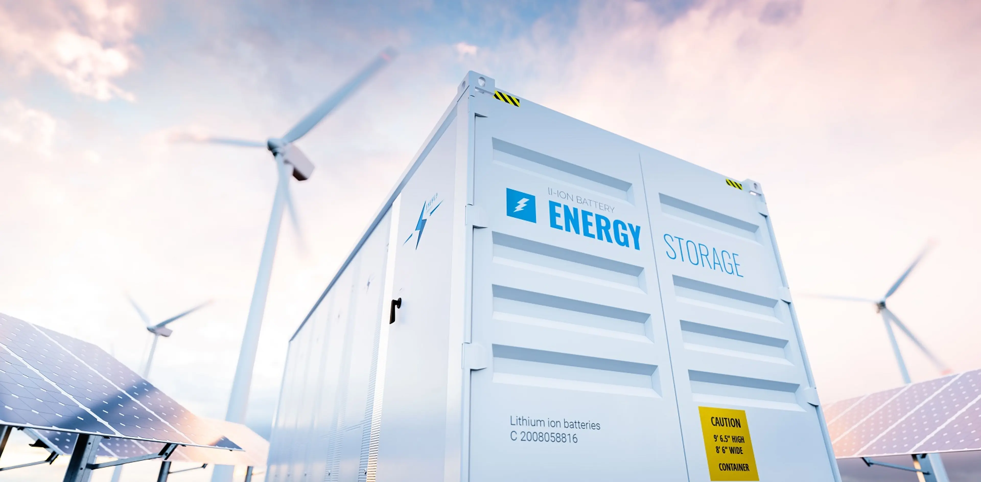 Stromspeichercontainer vor Windrädern zwischen Photovoltaik