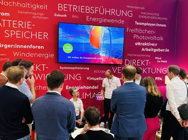 Besucher:innen am Stand der enercity Erneuerbare lauschen gespannt einem Vortrag über Windenergie