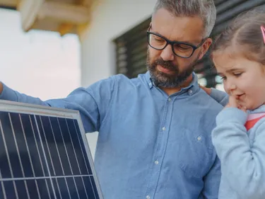 Ein Vater erklärt seiner Tochter eine Solaranlage