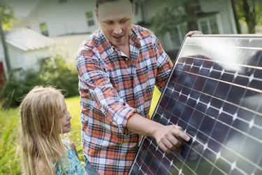 Vater mit Tochter vor einer Solarzelle