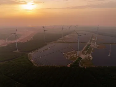 Windpark und Photovoltaik-Anlagen im Sonnenaufgang